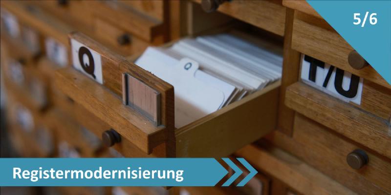 Geöffnetes Schubfach eines hölzernen Karteikartenkatalogs mit sichtbaren Karteikarten